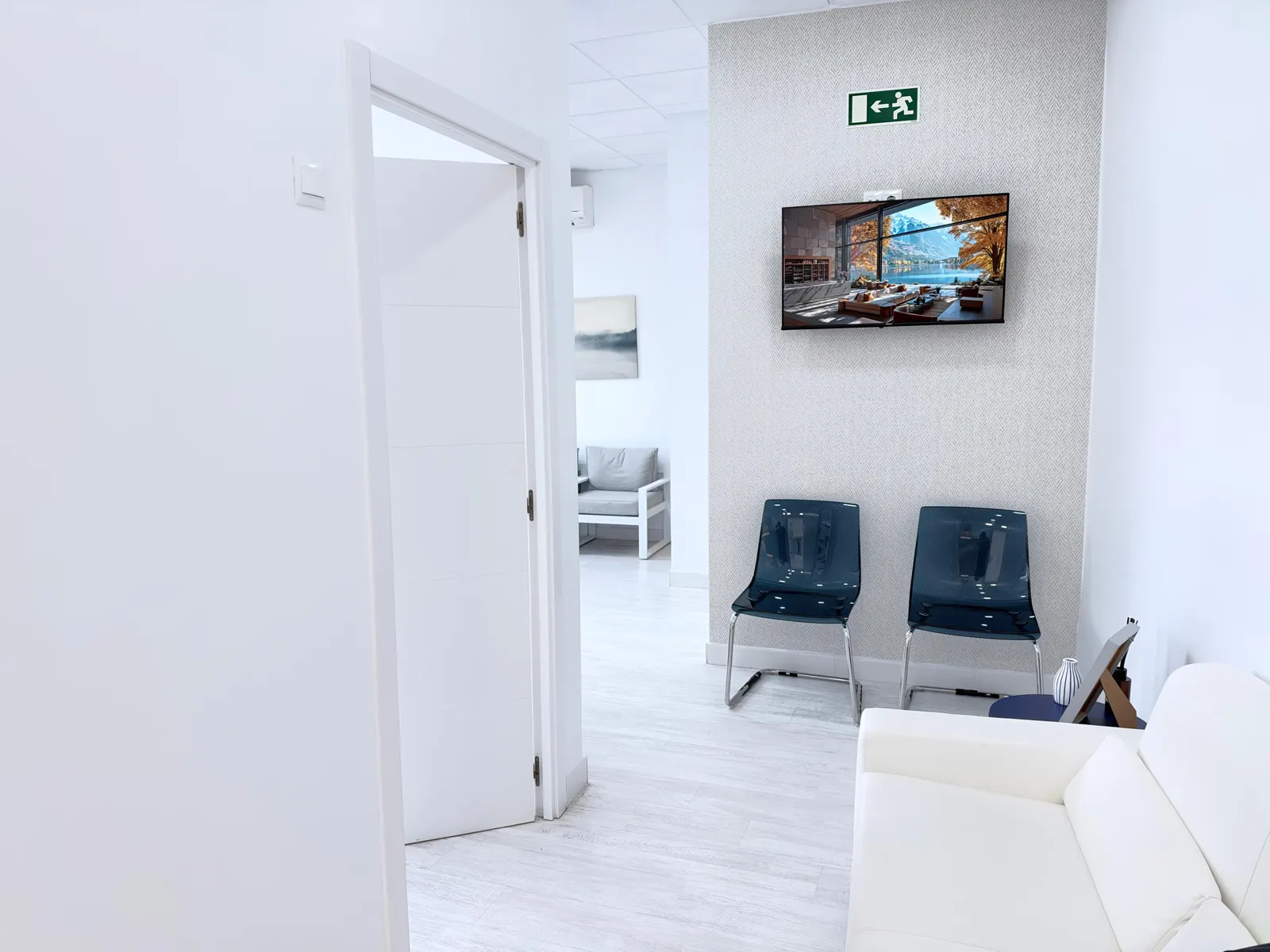 Zona de espera con pantalla en Clínica Dental Novalis